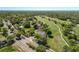 An aerial view shows homes bordering the golf course surrounded by mature trees in the community at 3960 Villas Green Cir, Longwood, FL 32779