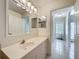 Bright bathroom featuring a single sink vanity and tile flooring, adjacent to hallway at 3960 Villas Green Cir, Longwood, FL 32779