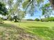 Scenic golf course view featuring a vibrant green fairway framed by mature trees and blue sky at 3960 Villas Green Cir, Longwood, FL 32779