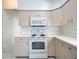 Kitchen with light wood cabinets, white appliances, and tile flooring at 3960 Villas Green Cir, Longwood, FL 32779