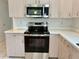Modern kitchen appliances featuring a stainless steel microwave and oven with light wood cabinetry at 3960 Villas Green Cir, Longwood, FL 32779