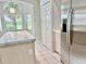Kitchen island near stainless steel refrigerator with view to backyard and arched window at 3960 Villas Green Cir, Longwood, FL 32779