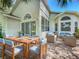 Covered patio with a dining table, seating area, and view of landscaped yard at 3960 Villas Green Cir, Longwood, FL 32779