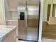 Side-by-side stainless steel refrigerator with water dispenser. View to kitchen and other rooms at 3960 Villas Green Cir, Longwood, FL 32779