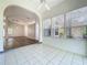 Bright sunroom featuring white tile floors, ceiling fan, many windows, and an arched entry into the main living area at 3960 Villas Green Cir, Longwood, FL 32779