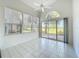 Bright sunroom featuring white tile floors, high vaulted ceiling with fan, and sliding glass doors to the outdoors at 3960 Villas Green Cir, Longwood, FL 32779