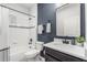 Modern bathroom featuring a bathtub, tiled walls, and a sleek vanity with a black framed mirror at 4622 Eureka Ln, Sanford, FL 32773