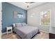 Serene bedroom with a blue accent wall, a cozy bed, and natural light from the windows at 4622 Eureka Ln, Sanford, FL 32773