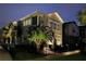 Beautiful townhome exterior at dusk, featuring manicured landscaping, accent lighting, and a secure fenced yard at 4622 Eureka Ln, Sanford, FL 32773