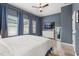 Serene bedroom with blue curtains, wood floors, and a white dresser beneath the wall-mounted television at 4622 Eureka Ln, Sanford, FL 32773