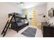 A bedroom with a dark wood bunk bed, yellow striped curtains, and playful decor creates a fun space at 4741 Clock Tower Dr # 201, Kissimmee, FL 34746