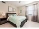 Bright bedroom with tile floors, calming decor, ensuite, and lots of natural light from a large window at 4741 Clock Tower Dr # 201, Kissimmee, FL 34746