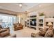 Comfortable living room featuring neutral carpeting, a custom built-in media center, and sliding glass doors to the patio at 512 Weston Pl, Debary, FL 32713