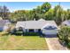 Expansive aerial view showcasing the property's mature landscaping, neutral color palette, and attached two-car garage at 7646 Covedale Dr, Orlando, FL 32818