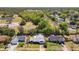 Suburban aerial view featuring tree coverage, neighboring homes, and the property's mature landscaping at 7646 Covedale Dr, Orlando, FL 32818