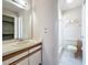 Well-lit bathroom featuring a vanity sink, mirror, and access to the shower at 7646 Covedale Dr, Orlando, FL 32818