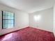 Bright bedroom featuring a window and pink carpet at 7646 Covedale Dr, Orlando, FL 32818