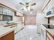 Bright kitchen features white appliances and cabinetry, tile floors, and a ceiling fan at 7646 Covedale Dr, Orlando, FL 32818