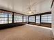 Enclosed sunroom featuring a ceiling fan, large windows and an indoor/outdoor carpet at 7646 Covedale Dr, Orlando, FL 32818