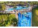 Aerial view of a community pool and splash park, surrounded by palm trees at 7675 Comrow St # 204, Kissimmee, FL 34747