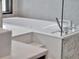 Close-up of a bathtub with a tiled backdrop, modern faucet, and a glass partition at 8521 Lake Nona Shore Dr, Orlando, FL 32827