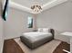 Minimalist bedroom with a platform bed, hardwood floors, and elegant chandelier at 8521 Lake Nona Shore Dr, Orlando, FL 32827