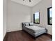 Minimalist bedroom with hardwood floors, two windows, and a neutral color palette at 8521 Lake Nona Shore Dr, Orlando, FL 32827