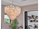 Charming chandelier hangs over an indoor dining space with outdoor kitchen view at 8521 Lake Nona Shore Dr, Orlando, FL 32827