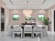 Dining room features a modern chandelier, large windows, and neutral decor at 8521 Lake Nona Shore Dr, Orlando, FL 32827