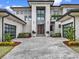 Contemporary home with a gray brick driveway, modern garage doors, and decorative front plants at 8521 Lake Nona Shore Dr, Orlando, FL 32827