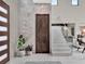 Elegant foyer featuring marble tile, a wood door, and a contemporary staircase with glass railings at 8521 Lake Nona Shore Dr, Orlando, FL 32827