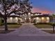 Elegant home featuring a grand entrance, manicured landscaping, and an inviting driveway for luxurious curb appeal at 8521 Lake Nona Shore Dr, Orlando, FL 32827