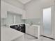 Bright laundry room with white cabinets, subway tile backsplash, and modern appliances at 8521 Lake Nona Shore Dr, Orlando, FL 32827