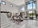 Open living room with high ceilings, large windows, a modern staircase, and contemporary furniture at 8521 Lake Nona Shore Dr, Orlando, FL 32827