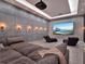 Luxurious media room with a large sectional sofa, projector screen, and ambient lighting at 8521 Lake Nona Shore Dr, Orlando, FL 32827