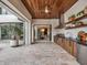 Covered outdoor kitchen with a view of the outdoor living and dining areas at 8521 Lake Nona Shore Dr, Orlando, FL 32827