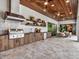 Expansive covered outdoor kitchen and dining area with wood ceiling and travertine flooring at 8521 Lake Nona Shore Dr, Orlando, FL 32827