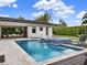 Stunning backyard oasis featuring a modern pool, integrated spa, and covered outdoor dining area for luxurious relaxation at 8521 Lake Nona Shore Dr, Orlando, FL 32827