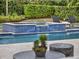 Up close view of the sparkling pool and spa featuring lovely tile work and water features in the backyard oasis at 8521 Lake Nona Shore Dr, Orlando, FL 32827