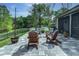 Beautiful backyard with Adirondack chairs around a fire pit on a stone patio surrounded by lush landscaping at 876 Kensington Gardens Ct, Oviedo, FL 32765