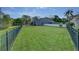 Expansive backyard with lush green grass, iron fence, and mature landscaping at 876 Kensington Gardens Ct, Oviedo, FL 32765