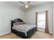 Cozy bedroom features a black bed frame, neutral-toned walls, and a window with natural light, creating a comfortable retreat at 876 Kensington Gardens Ct, Oviedo, FL 32765