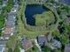 Aerial view of houses in a community that features a picturesque pond surrounded by lush greenery at 876 Kensington Gardens Ct, Oviedo, FL 32765