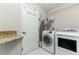 Laundry room featuring white washer and dryer, counter space, and overhead storage at 876 Kensington Gardens Ct, Oviedo, FL 32765