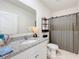 Bathroom featuring granite sink, modern shelf, and a shower with a gray curtain at 965 Lido Dr, Howey In The Hills, FL 34737