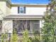 Rear exterior view of the home featuring a screened patio and well-manicured landscaping at 965 Lido Dr, Howey In The Hills, FL 34737