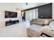 Living room features neutral tile flooring, a sliding glass door, and a comfortable gray sofa at 965 Lido Dr, Howey In The Hills, FL 34737