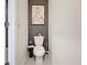 Small half bathroom featuring white toilet and dark accent wall with elephant art at 965 Lido Dr, Howey In The Hills, FL 34737