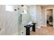 Modern bathroom featuring a glass-enclosed shower with black fixtures and a bench for towels at 985 Tassleflower Trl, St Cloud, FL 34771