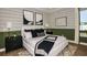 Comfortable bedroom with a large bed, black and white bedding, stylish wallpaper, and two black nightstands at 985 Tassleflower Trl, St Cloud, FL 34771